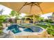 Beautiful backyard with a pool, an outdoor kitchen, manicured greenery, and a shaded seating area at 4450 S Frequency --, Mesa, AZ 85212