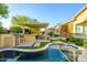 Resort-style backyard features a sparkling pool, covered patio, outdoor kitchen, and mature landscaping at 4450 S Frequency --, Mesa, AZ 85212