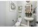 Stylish powder room with a pedestal sink, decorative mirror, and elegant fixtures at 4450 S Frequency --, Mesa, AZ 85212