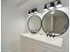 Bright bathroom featuring double vanity with oval mirrors and modern black fixtures at 6813 W Sherri Jean Ln, Peoria, AZ 85382
