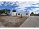 A single-story white home with a long driveway offers ample parking for residents and guests at 6813 W Sherri Jean Ln, Peoria, AZ 85382