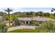 Beautiful house with circular driveway, manicured lawn, and lush landscaping with mountain views in the distance at 7272 N 71St St, Paradise Valley, AZ 85253