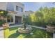 View of a landscaped backyard with fountain, artificial grass, and stylish patio, ideal for entertaining at 7296 E San Alfredo Dr, Scottsdale, AZ 85258