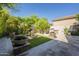 Landscaped backyard featuring a stone fountain, lush greenery, and a paved patio area, great for outdoor living at 7296 E San Alfredo Dr, Scottsdale, AZ 85258
