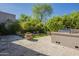 Beautifully landscaped backyard featuring a stone fountain, outdoor kitchen, and spacious patio for entertaining at 7296 E San Alfredo Dr, Scottsdale, AZ 85258