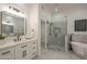 Bright bathroom featuring a white vanity and framed mirror with a view of a tiled shower and tub at 7296 E San Alfredo Dr, Scottsdale, AZ 85258
