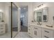 Bright bathroom with large mirror, white vanity and view into hallway and living area at 7296 E San Alfredo Dr, Scottsdale, AZ 85258