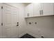 Clean laundry room with white cabinets and a black hexagon tile floor at 7296 E San Alfredo Dr, Scottsdale, AZ 85258