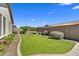 Lush backyard with manicured lawn, decorative landscaping, and a serene outdoor space at 7407 E Portobello Ave, Mesa, AZ 85212