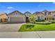 Well-maintained home with lush green lawn, manicured shrubs and brick driveway at 7407 E Portobello Ave, Mesa, AZ 85212