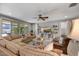 Cozy living room with large couch, ceiling fan, TV, and sliding glass doors at 7407 E Portobello Ave, Mesa, AZ 85212