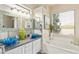 Luxurious bathroom with dual sinks, decorative mirrors, and a soaking tub at 7754 E Wolf Canyon St, Mesa, AZ 85207