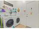Well-equipped laundry room with washer, dryer, shelving and door access at 7754 E Wolf Canyon St, Mesa, AZ 85207
