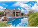 Stunning backyard with a large pool, hot tub, covered patio, spiral staircase and desert landscaping at 7754 E Wolf Canyon St, Mesa, AZ 85207