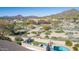 View of a rooftop patio with outdoor furniture, a lawn, and a pool against a desert mountain landscape backdrop at 7754 E Wolf Canyon St, Mesa, AZ 85207