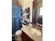 Bathroom featuring a single sink vanity, open shelving unit, and a shower/tub with a curtain at 7901 W Tuckey Ln, Glendale, AZ 85303