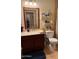 Bathroom features a single sink vanity with wood cabinets, white walls, decor, and a toilet at 7901 W Tuckey Ln, Glendale, AZ 85303