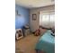 A bedroom with light carpet features a blue accent wall, a window, and a decor at 7901 W Tuckey Ln, Glendale, AZ 85303