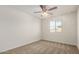 Carpeted bedroom featuring a ceiling fan, window, and neutral paint scheme at 829 E Agua Fria Ln, Avondale, AZ 85323