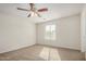 Carpeted bedroom featuring a ceiling fan, window, and neutral paint scheme at 829 E Agua Fria Ln, Avondale, AZ 85323