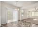 Bright dining area features wood-look floors, a modern chandelier, and sliding glass doors to the patio at 829 E Agua Fria Ln, Avondale, AZ 85323
