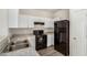 Well-lit kitchen featuring white cabinets, black appliances, and stylish countertops and flooring at 829 E Agua Fria Ln, Avondale, AZ 85323