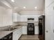 Modern kitchen with white cabinets, granite countertops, and black appliances, offering a sleek design at 829 E Agua Fria Ln, Avondale, AZ 85323