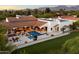 Expansive aerial view of a luxury home, showcasing a beautiful pool, patio, and mountain views at 8515 E Sutton Dr, Scottsdale, AZ 85260