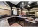 Well-appointed bar area featuring granite countertops, custom cabinets, wine coolers, and mirrored backsplash near game room at 8515 E Sutton Dr, Scottsdale, AZ 85260