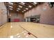 Spacious indoor basketball court with brick walls, skylights, and hardwood flooring leading to a billiards area at 8515 E Sutton Dr, Scottsdale, AZ 85260