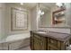 Elegant bathroom featuring a tub and a vanity with a dark countertop and decorative tiling accents at 8515 E Sutton Dr, Scottsdale, AZ 85260