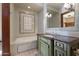 Well-lit bathroom features a soaking tub, decorative tile, and a stylish green vanity at 8515 E Sutton Dr, Scottsdale, AZ 85260