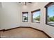 Bedroom featuring neutral carpet and view of outdoor pool through three windows at 8515 E Sutton Dr, Scottsdale, AZ 85260