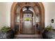 Grand entryway featuring a stone archway and wooden door, leading to pool views beyond at 8515 E Sutton Dr, Scottsdale, AZ 85260