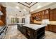 Gourmet kitchen features a large island with marble countertop, custom cabinetry, and designer lighting at 8515 E Sutton Dr, Scottsdale, AZ 85260