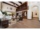 A spacious living room with a fireplace, hardwood floors, exposed wood beams, and access to the backyard pool at 8515 E Sutton Dr, Scottsdale, AZ 85260