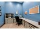 Stylish home office with custom built-in shelving, ample workspace, and a calming blue color scheme for productivity at 8515 E Sutton Dr, Scottsdale, AZ 85260