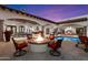 Luxury outdoor living area boasts a fireplace, pool, spa, and ample seating for stylish entertaining at 8515 E Sutton Dr, Scottsdale, AZ 85260