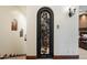 Ornate wine cellar entrance with wrought iron gate, beautiful stonework, and climate control for wine storage and display at 8515 E Sutton Dr, Scottsdale, AZ 85260