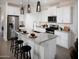 Bright kitchen with white cabinets, granite countertops, and stainless steel appliances at 8950 W Albeniz Pl, Tolleson, AZ 85353