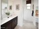 Modern bathroom with double sinks, dark wood cabinets, decorative art, and a walk-in shower at 8954 W Albeniz Pl, Tolleson, AZ 85353