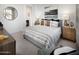 Comfortable bedroom with a striped bed, stylish bedside tables, and modern artwork creating a relaxing space at 8954 W Albeniz Pl, Tolleson, AZ 85353