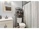 Well-lit bathroom featuring blue walls, a white vanity, and an iron etagere for storage at 9021 W Elm St # 7, Phoenix, AZ 85037