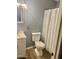 Cozy bathroom featuring a white toilet, vanity, and patterned shower curtain, complemented by neutral wall paint and wood-look flooring at 9021 W Elm St # 7, Phoenix, AZ 85037