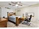Comfortable bedroom with a wooden bed frame, ceiling fan, and a dedicated workspace at 9021 W Elm St # 7, Phoenix, AZ 85037