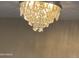 Close-up of an elegant chandelier providing additional lighting to the home's interior at 9021 W Elm St # 7, Phoenix, AZ 85037