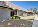 Exterior view of a one story home with a tile roof, small yard, and sidewalk at 9021 W Elm St # 7, Phoenix, AZ 85037