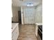 Modern kitchen featuring white cabinets and countertops, wood-look floors, and contemporary lighting at 9021 W Elm St # 7, Phoenix, AZ 85037