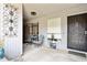 Cozy covered patio with seating area, decorative metal art, and a secure front entry at 9021 W Elm St # 7, Phoenix, AZ 85037