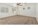 Spacious bedroom featuring neutral walls, carpet flooring, ceiling fan, and a large window at 9234 W Hedge Hog Pl, Peoria, AZ 85383